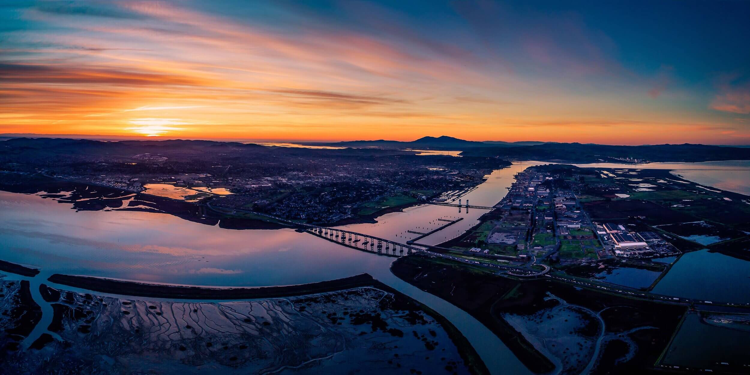 Personal Injury Trial Attorney Locations 49 Aerial view of sunset over a river.
